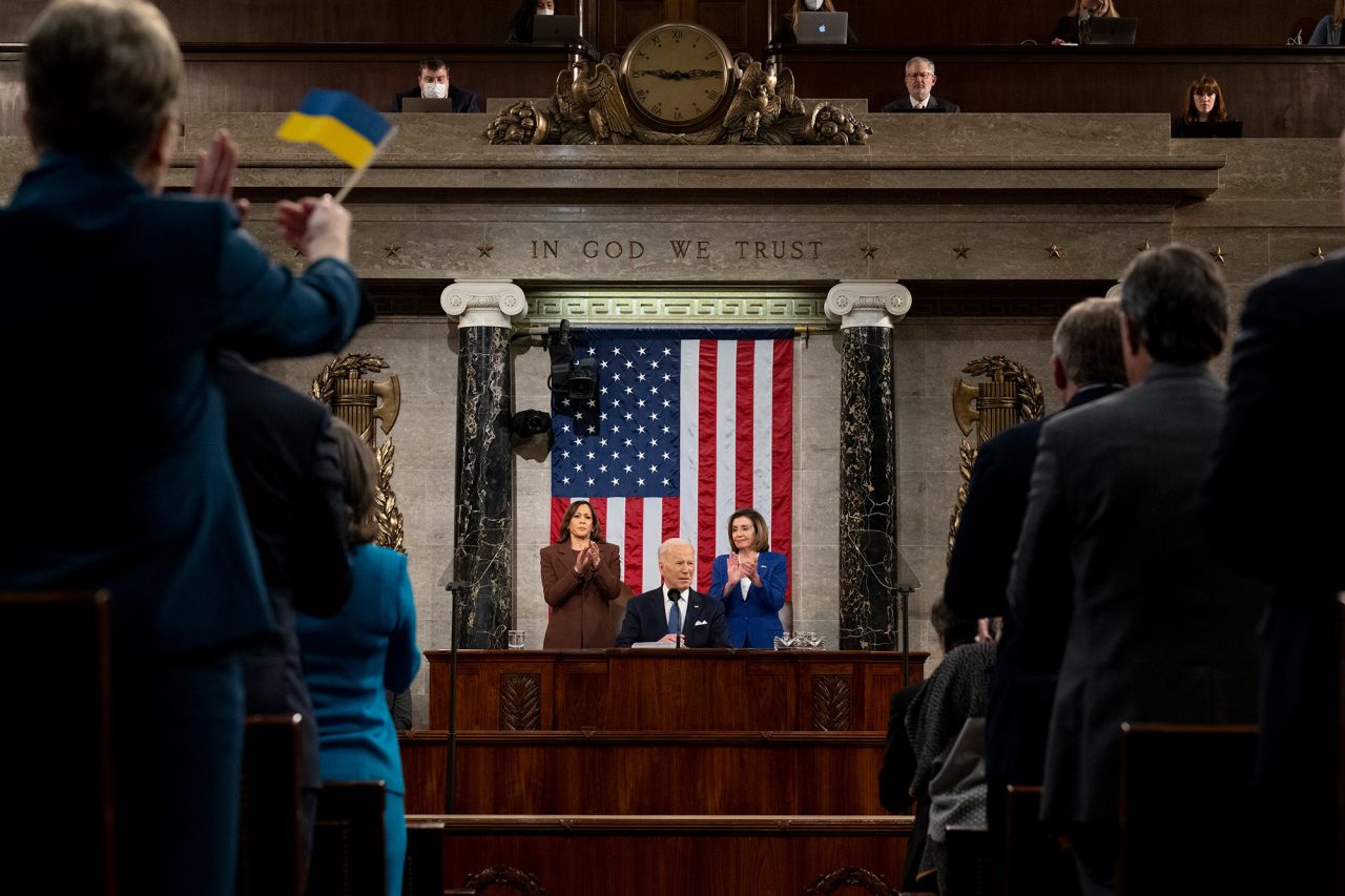 A Ukrainian flag is waved in the audience while Biden speaks.