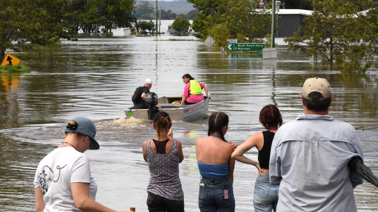 Residents stand by a flooded street in Lawrence suburb, some 70 kilometers New South Wales border city Lismore, on March 1, 2022. 