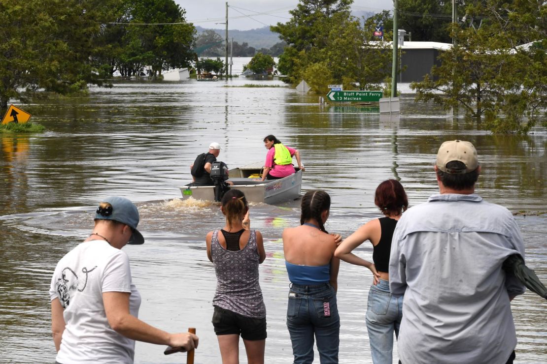 Residents stand by a flooded street in Lawrence suburb, some 70 kilometers New South Wales border city Lismore, on March 1, 2022. 