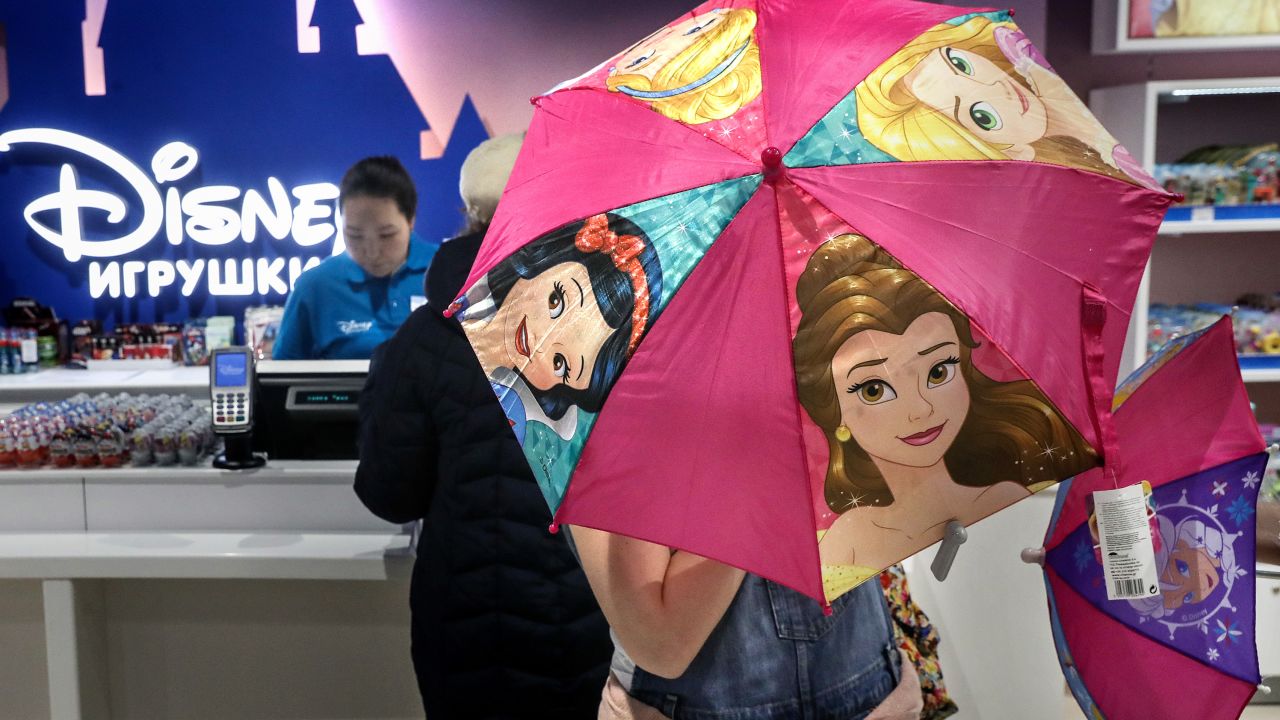 A shopper opening an umbrella featuring Disney Princesses at the Central Children's Store in Moscow's Lubyanka Square in 2017.