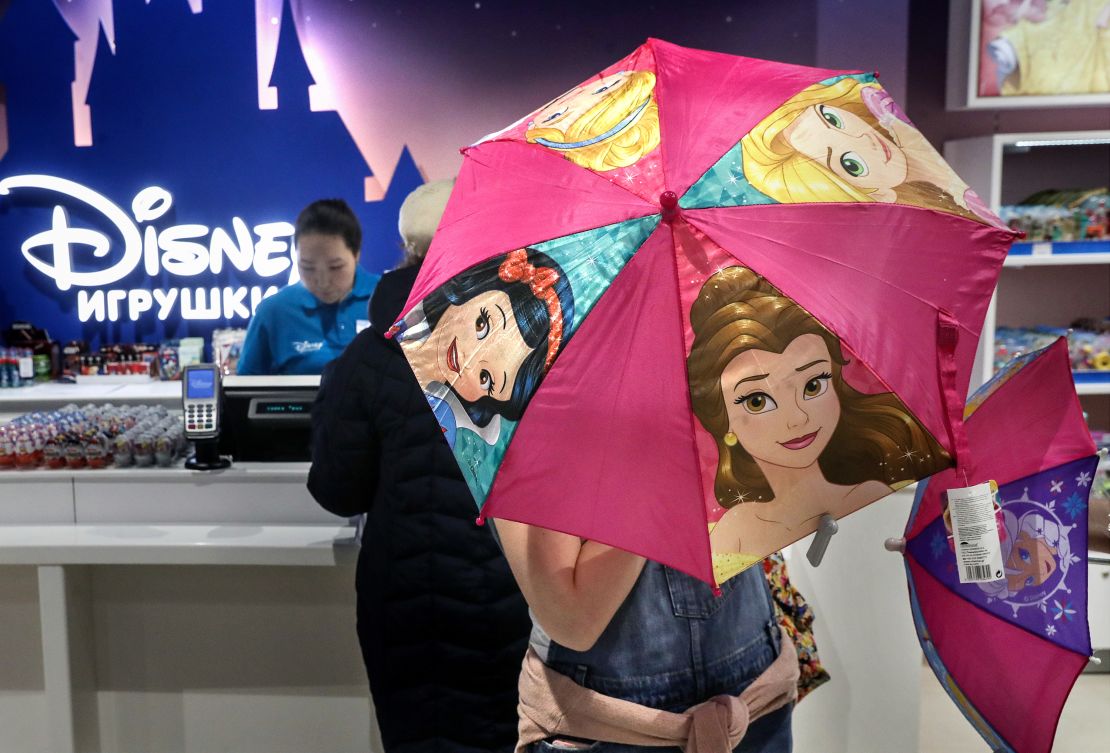 A shopper opening an umbrella featuring Disney Princesses at the Central Children's Store in Moscow's Lubyanka Square in 2017.