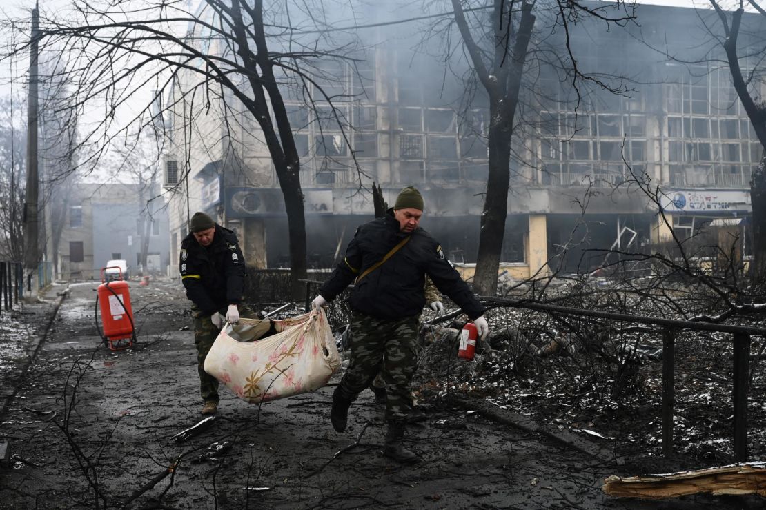 Police officers remove the body Wednesday of a passerby killed in an airstrike that hit Kyiv's main television tower.