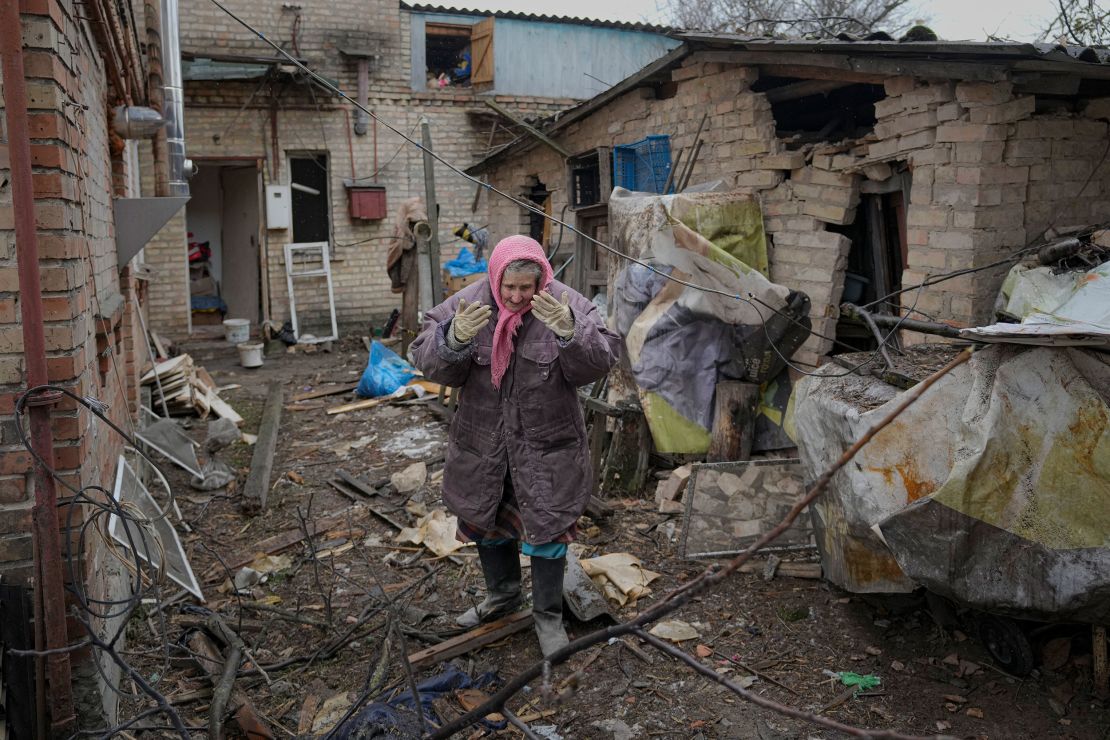 A woman surveys the backyard of a house damaged by a Russian airstrike, according to locals, in Gorenka, near Kyiv, on Wednesday.