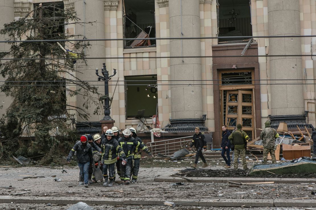 Ukrainian emergency service personnel carry the body of a victim following shelling of the Regional State Administration building in Kharkiv on Tuesday.