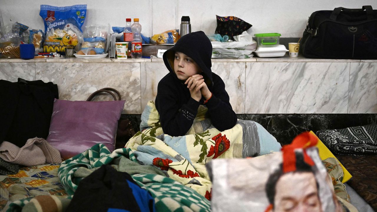 A boy sits at an underground metro station used as bomb shelter in Kyiv on March 2, 2022. 