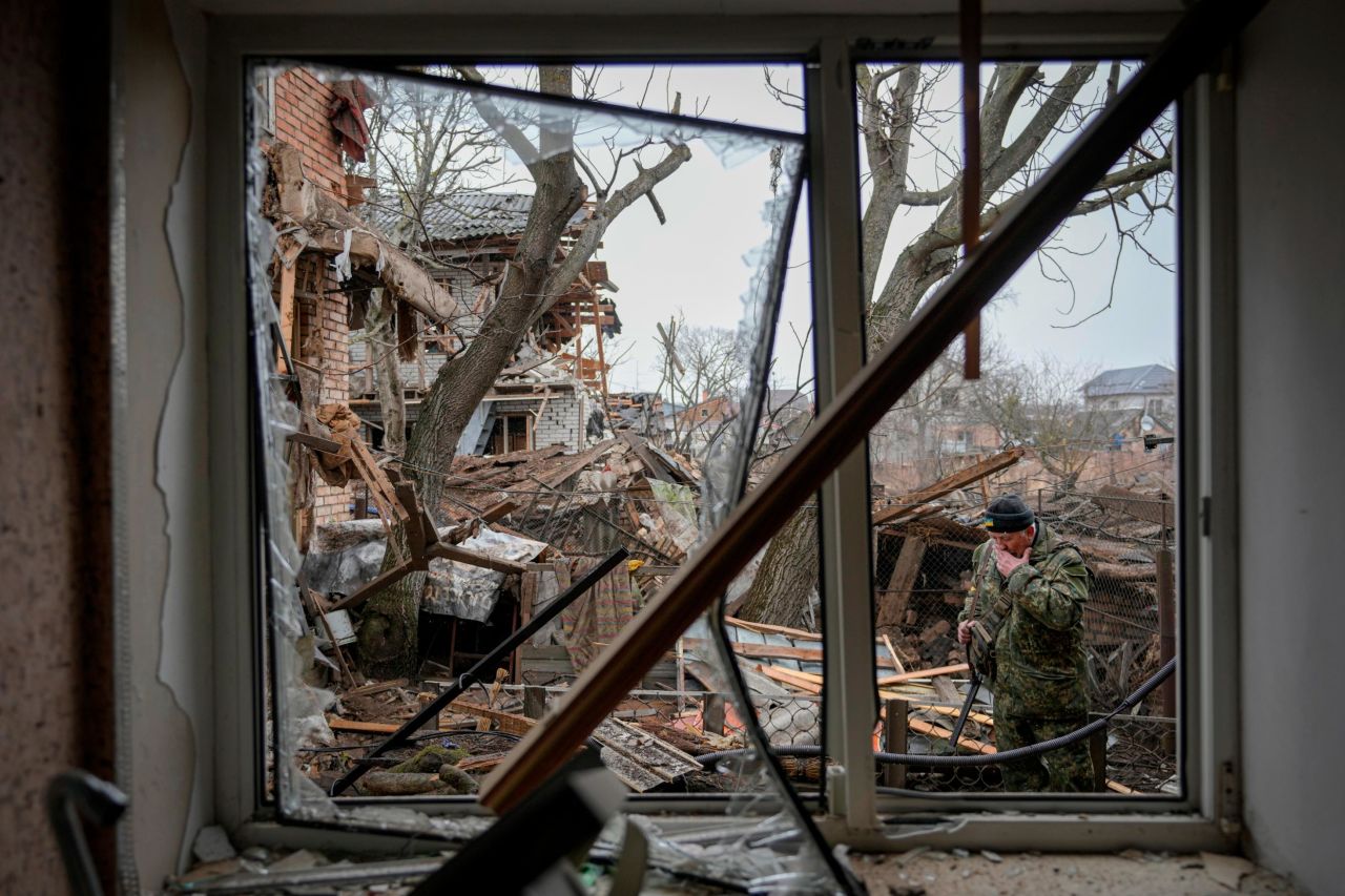 A member of Ukraine's Territorial Defense Forces inspects damage in the backyard of a house in Gorenka on March 2.