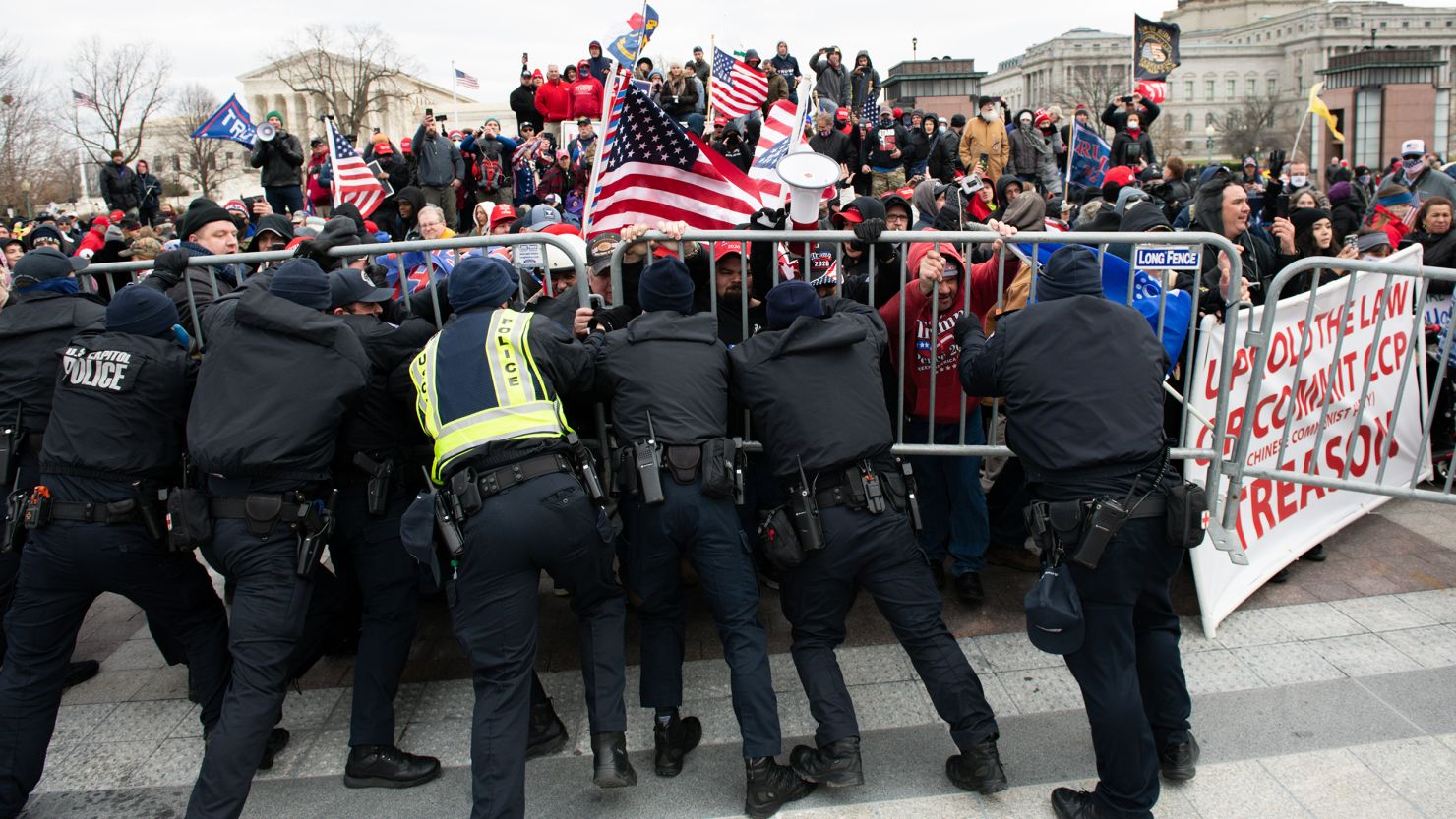 In this January 6, 2021, file photo, US Capitol Police scuffle with demonstrators after they broke through security fencing outside the Capitol in Washington.