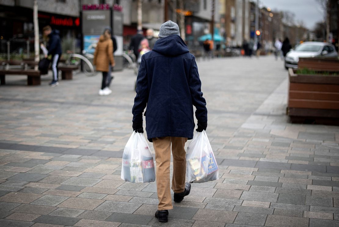 A shopper carries his purchases in Walthamstow, east London, on February 13.