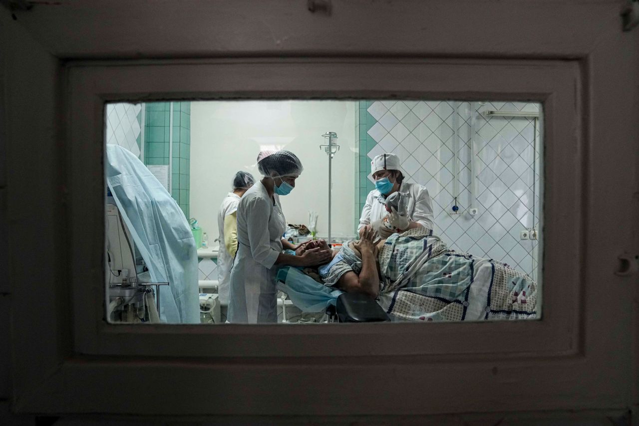 Medical workers show a mother her newborn after she gave birth at a maternity hospital in Mariupol on March 1.