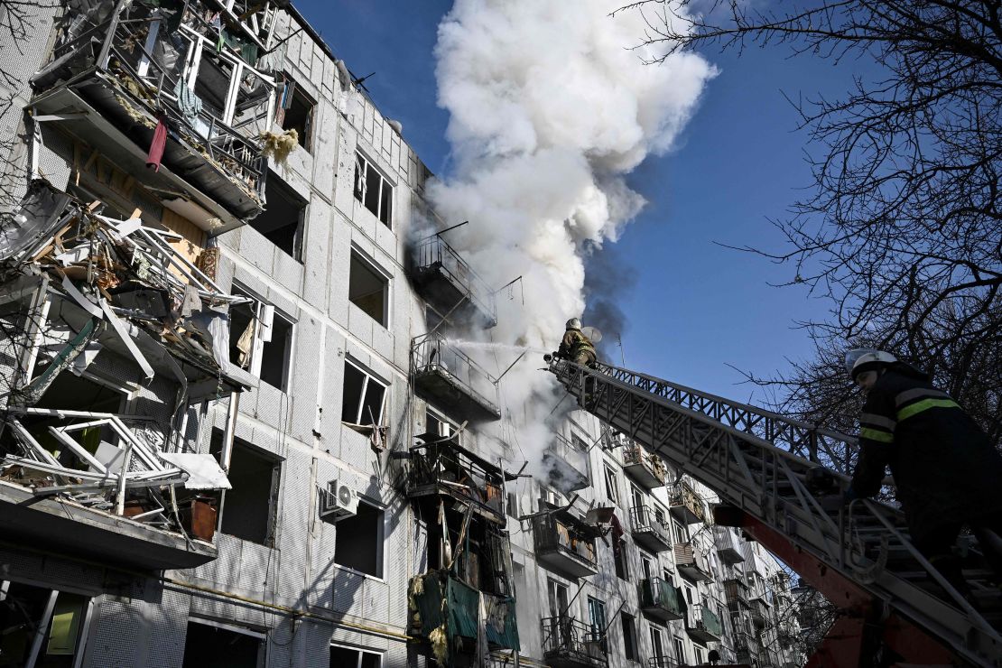 Firefighters work on a fire on a building after bombings on the eastern Ukraine town of Chuguiv on February 24, 2022.