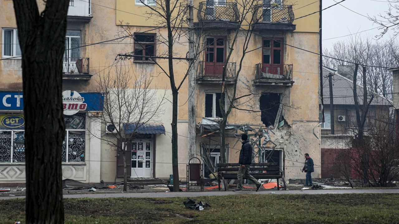 A man passes an apartment building hit by shelling in Mariupol, Ukraine on Wednesday.