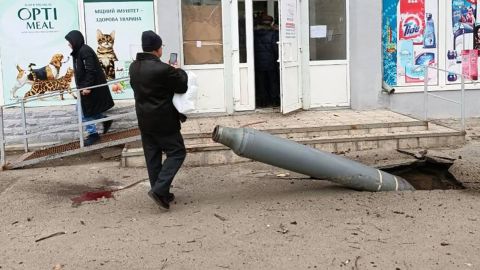A missile is seen lodged in the ground outside a small grocery store in Kharkiv on Monday.