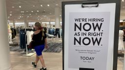 A customer walks behind a sign at a Nordstrom store seeking employees in Coral Gables, Florida, May 21, 2021.