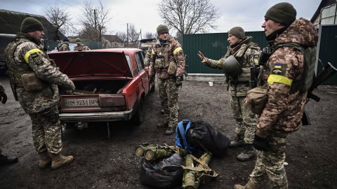 Ukrainian soldiers unload weapons from the trunk of an old car northeast of Kyiv, Ukraine. 
