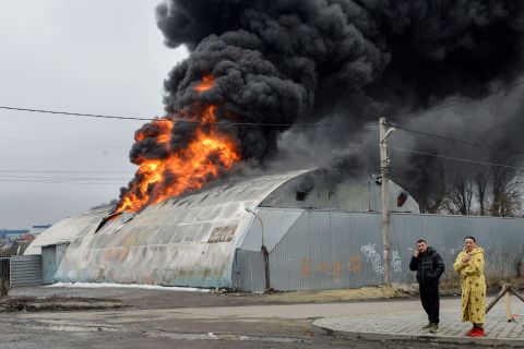 Residents react in front of a burning building after shelling in Kharkiv on March 3.
