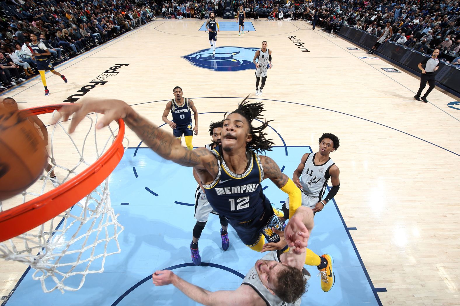 Memphis star Ja Morant <a href="index.php?page=&url=https%3A%2F%2Fwww.youtube.com%2Fwatch%3Fv%3DAtUq5fnMXR8" target="_blank" target="_blank">dunks over San Antonio's Jakob Poeltl</a> during an NBA game on Monday, February 28. Poeltl is 7 feet tall; Morant is 6-3.