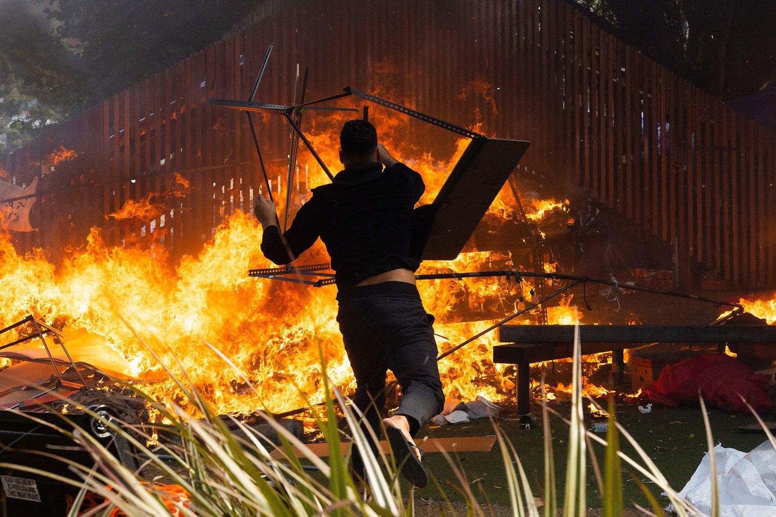 A man throws a desk onto a raging fire in front of New Zealand's Parliament as people continued to demonstrate against Covid-19 restrictions on Wednesday, March 2.