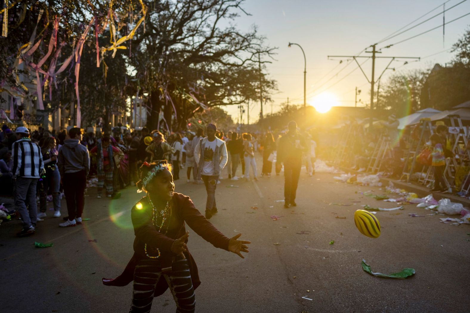 Saniah Collins, 10, throws a toy football with a friend while waiting for a Mardi Gras parade to begin in New Orleans on Sunday, February 27.