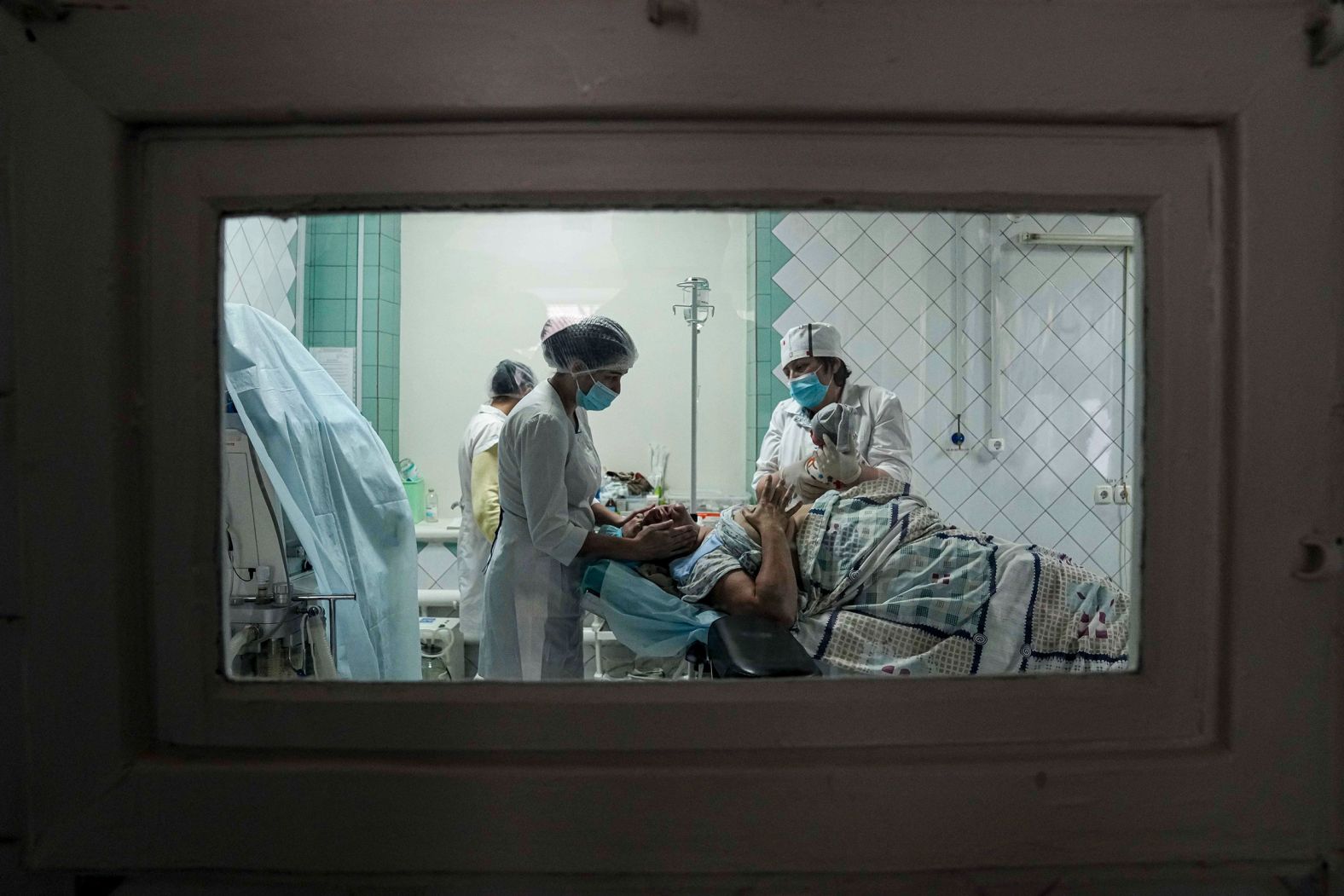 Medical workers show a mother her newborn after she gave birth at a maternity hospital in Mariupol, Ukraine, on Tuesday, March 1. The hospital is now also used as a medical ward and bomb shelter.