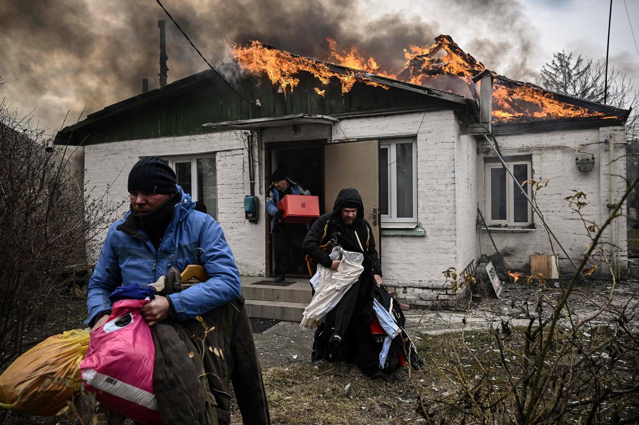 People remove personal belongings from a burning house after shelling in Irpin on March 4.  Zelensky says Russia waging war so Putin can stay in power &#8216;until the end of his life&#8217; w 1280