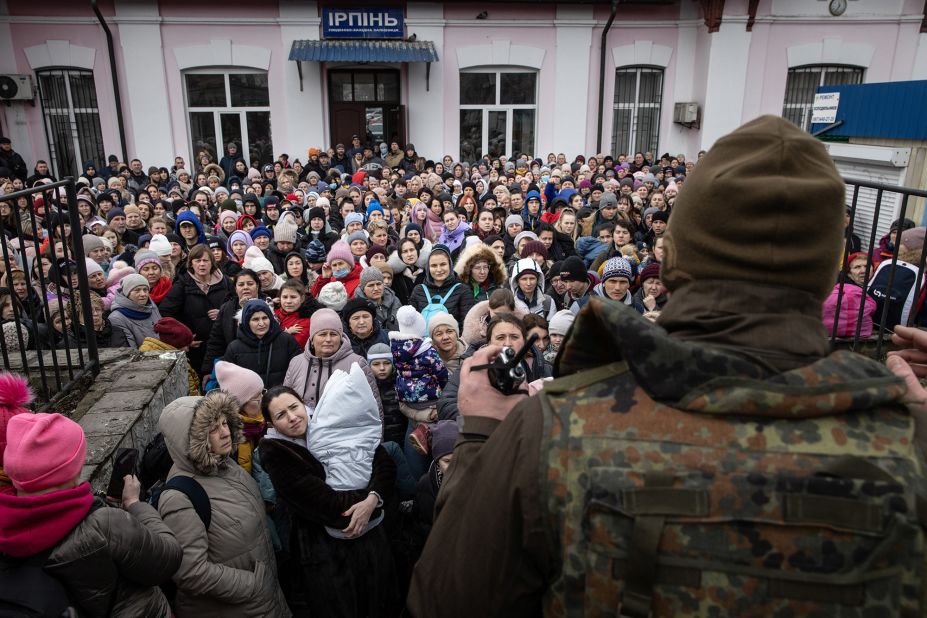 A member of the Ukrainian military gives instructions to civilians in Irpin on March 4. They were about to board an evacuation train headed to Kyiv.