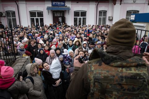 A member of the Ukrainian military gives instructions to civilians in Irpin on March 4. They were about to board an evacuation train headed to Kyiv.