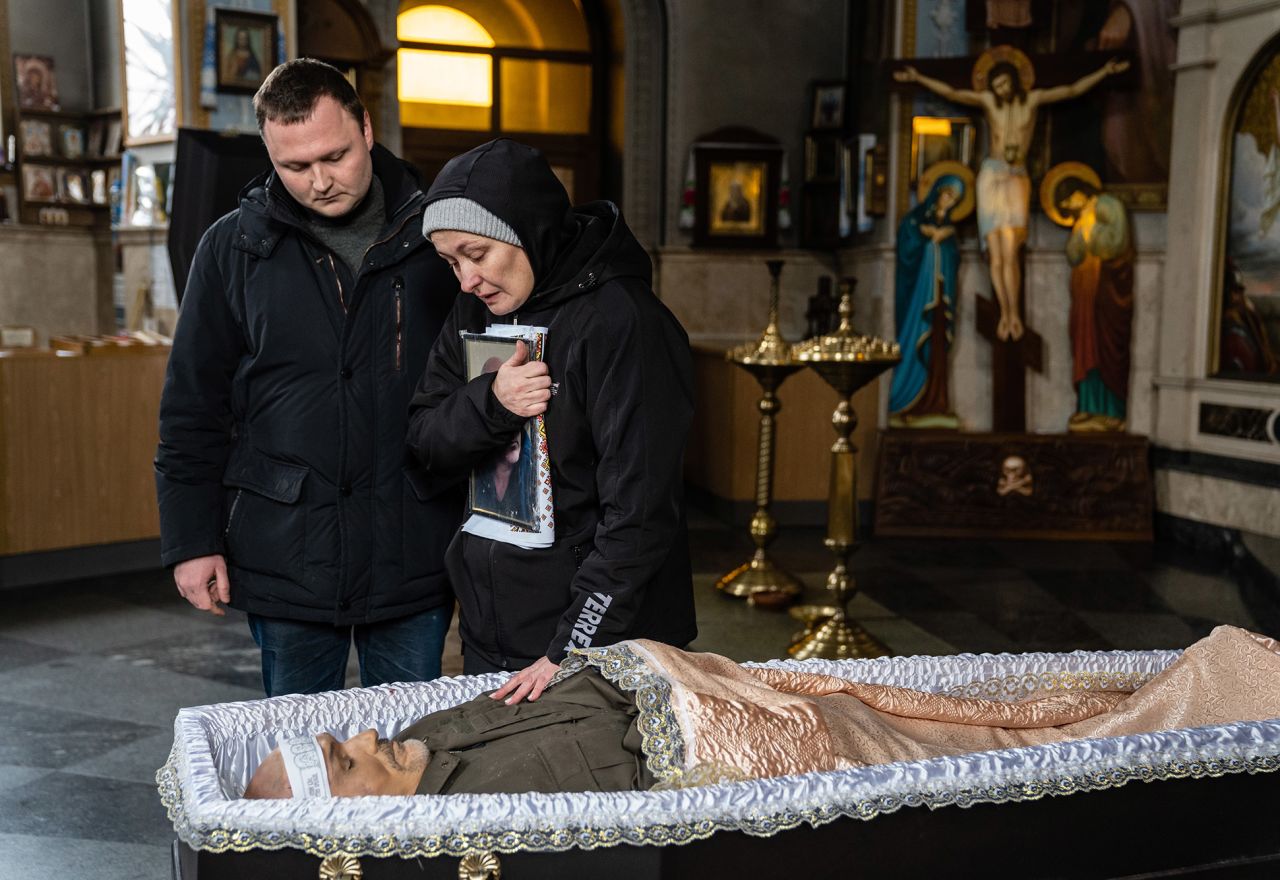 Oksana and her son Dmytro stand over the open casket of her husband, Volodymyr Nezhenets, during his funeral in Kyiv on March 4. <a target=