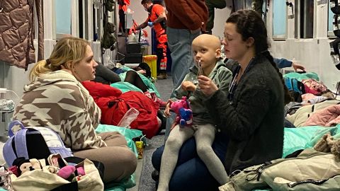 Szuszkiewicz sits with six-year-old Sophia, who clutches a toy given to her by volunteers on the train.
