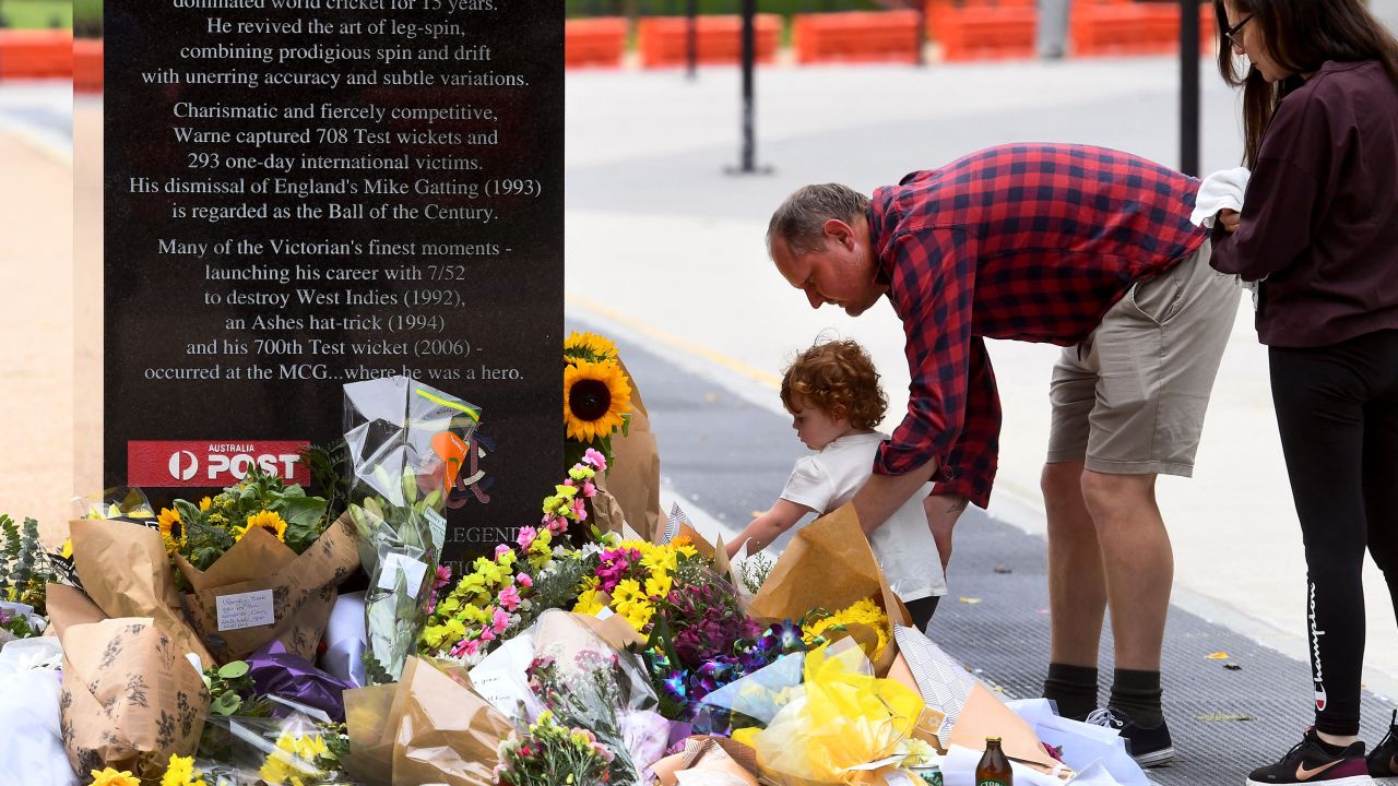 Flowers are placed at the base of a statue dedicated to Warne at the MCG.