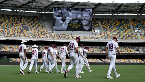 Queensland players walk in the outfield during a tribute to Warne at the Sheffield Shield match between Queensland and South Australia.
