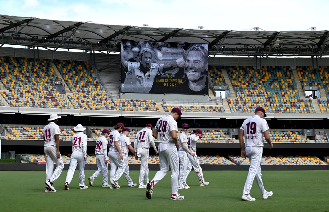 Queensland players walk in the outfield during a tribute to Warne at the Sheffield Shield match between Queensland and South Australia.