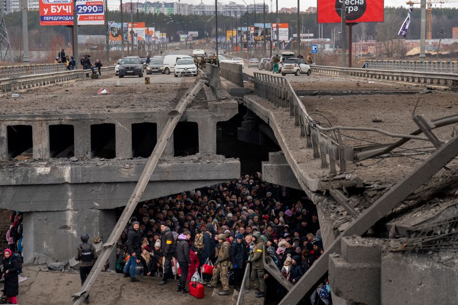 Ukrainians crowd under a destroyed bridge as they try to flee across the Irpin River on the outskirts of Kyiv on March 5.