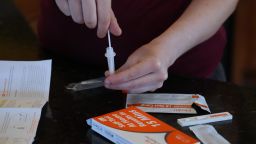 A Walmart worker processes a nasal swab in one of the new government-issued COVID-19 Antigen Rapid test kits she received as she self tests while at home on February 8, 2022 in Provo, Utah.