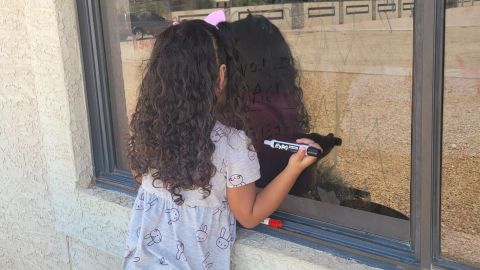 Donnell's youngest, 4-year-old Aariyah, looks into her father's window at a care facility in July 2021.