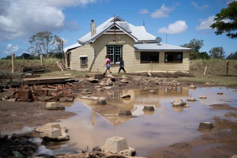 Alison Broughey, left, inspects her destroyed home, whose foundations have been swept away, near Werallah, Australia, on March 4.