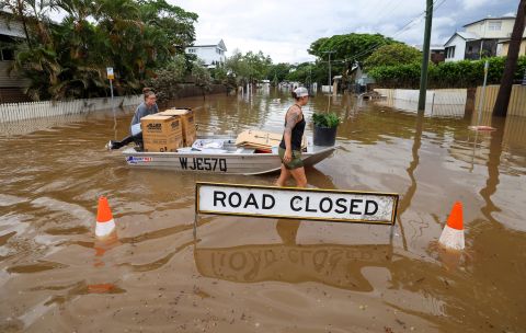 People use a boat to save items from their home in Brisbane, Australia, on March 3.