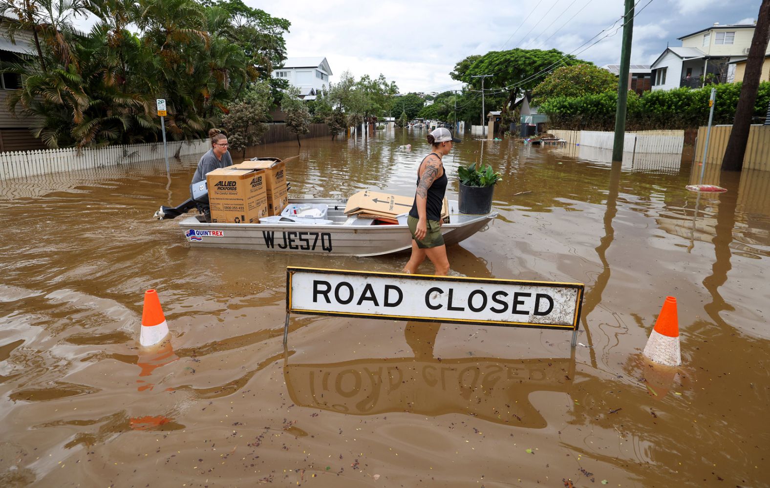 People use a boat to save items from their home in Brisbane, Australia, on March 3.