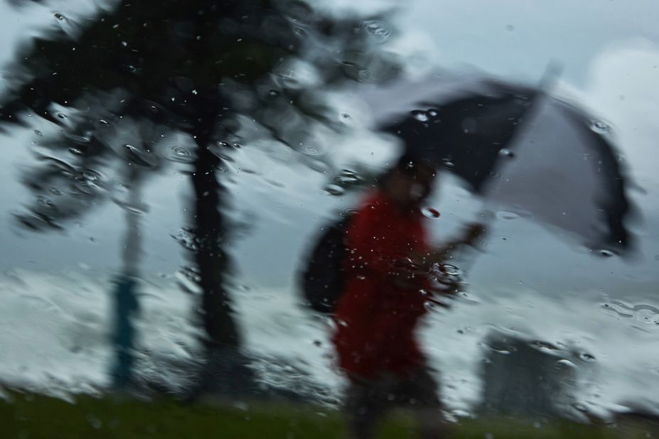 A person walks through rain at Manly Beach in Sydney on March 3.