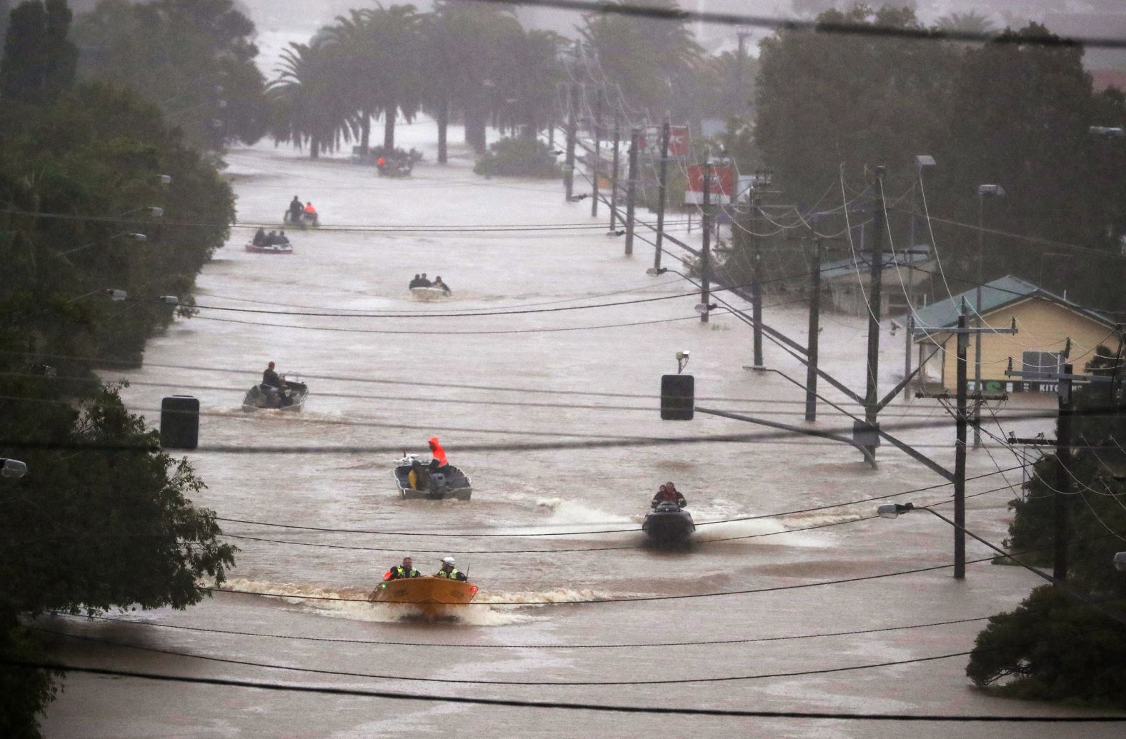 People use small boats to travel through floodwaters in Lismore on February 28.