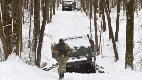 A Ukrainian soldier walks by destroyed Russian military vehicles in a forest outside Kharkiv on Monday. 