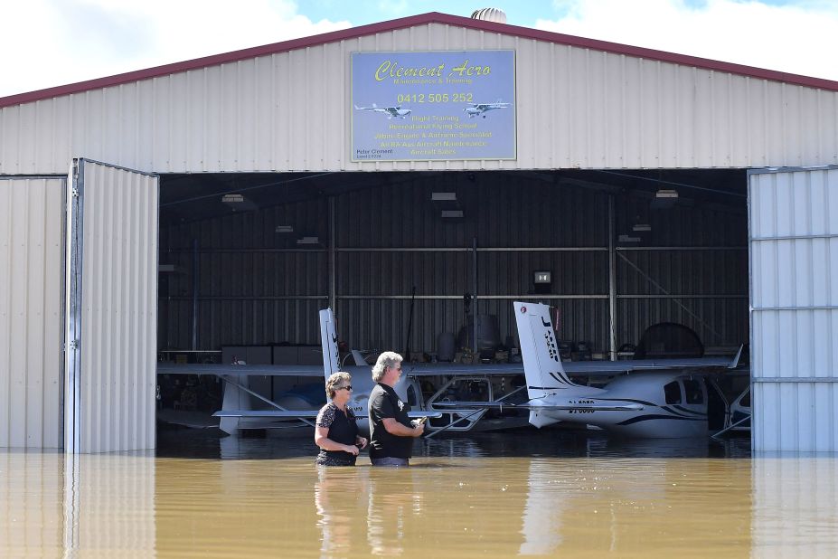 Flying instructor Peter Clement, right, and his wife Kerrie stand in waist-high water as they examine their aircraft inside a flooded hanger at Grafton Air Strip in Grafton, Australia, on March 2.