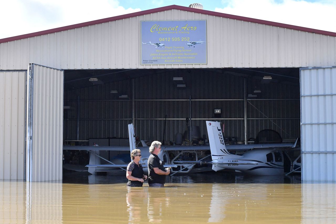Flying instructor Peter Clement, right, and his wife Kerrie stand in waist-high water as they examine their aircraft inside a flooded hanger at Grafton Air Strip in Grafton, Australia, on March 2.