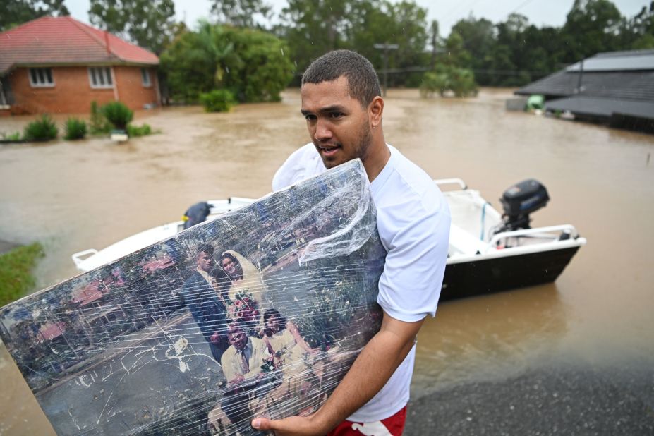 A man carries a wedding photo as people evacuate homes in Goodna, Australia, on February 27.