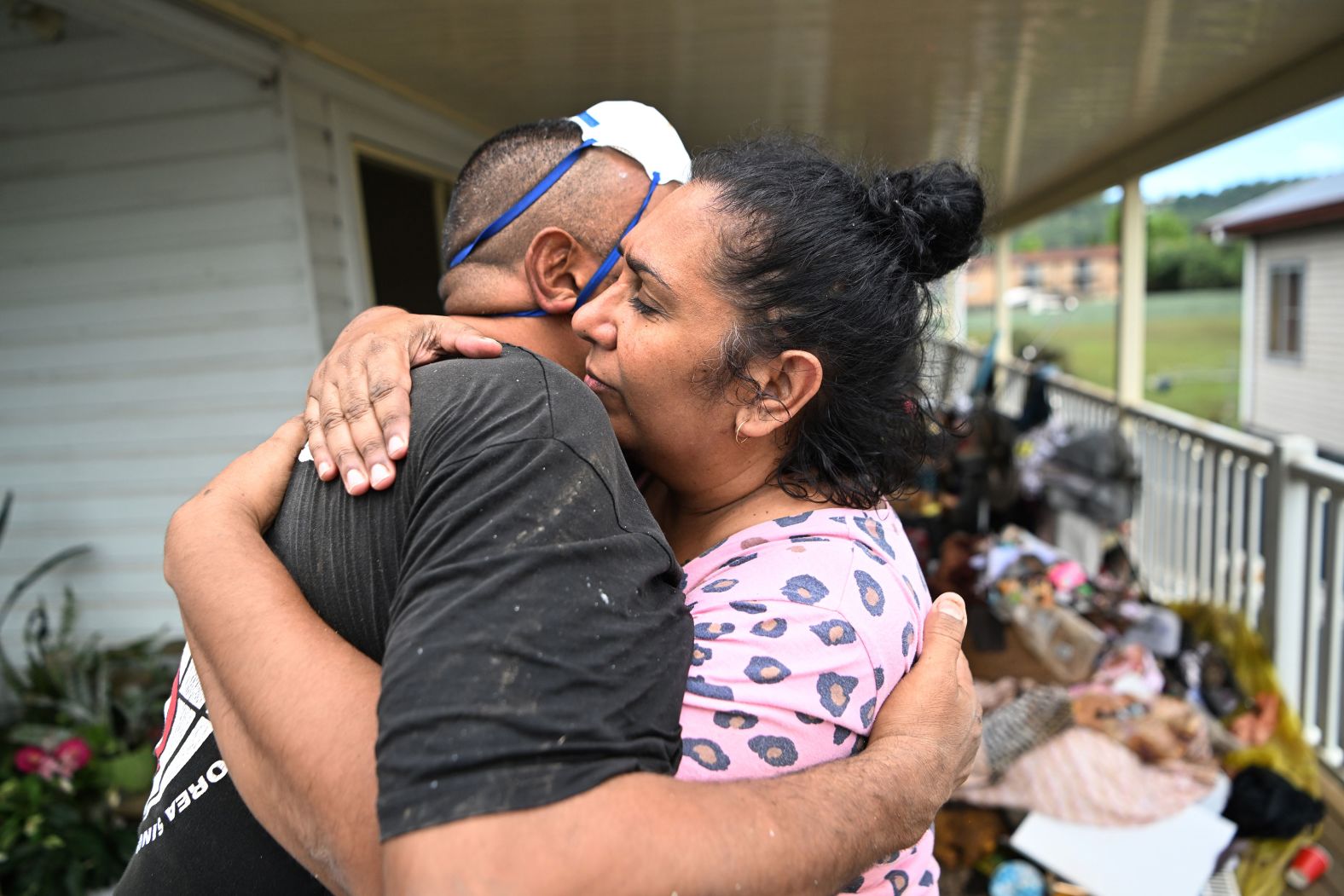 Michele Laurie hugs a work colleague who came to help in the cleanup of her home in Lismore on March 3.