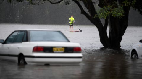 A man navigates floodwaters from the swollen Manly Creek in Manly Vale, Australia, on March 8.