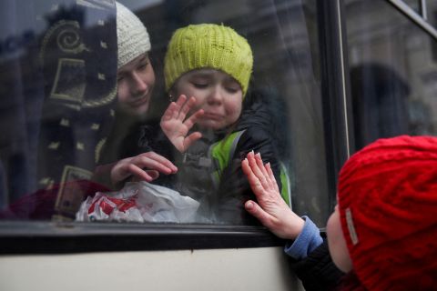 Alexandra, 12, holds her 6-year-old sister, Esyea, who cries as she waves at her mother, Irina, on March 7. The children were leaving Odesa, Ukraine.