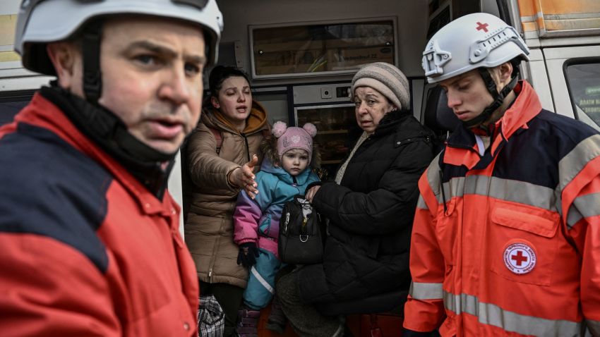 TOPSHOT - Members of the Red Cross help people who flee the city of Irpin, west of Kyiv, on March 7, 2022. - Russian forces pummelled Ukrainian cities from the air, land and sea on Monday, with warnings they were preparing for an assault on the capital Kyiv, as terrified civilians failed for a second day to escape besieged Mariupol. (Photo by ARIS MESSINIS / AFP) (Photo by ARIS MESSINIS/AFP via Getty Images)