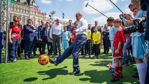 Vladimir Poetin trapt een voetbal tijdens een evenement op het Rode Plein op 28 juni 2018 in Moskou.