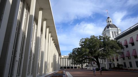 People walk between the Florida State Capitol building, left, and the Florida Historic Capitol Museum, right, during a legislative session on Wednesday, January 12, 2022, in Tallahassee, Florida.