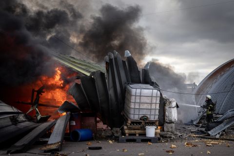 A firefighter works to extinguish flames after a chemical warehouse was reportedly hit by Russian shelling near Kalynivka, Ukraine, on March 8.